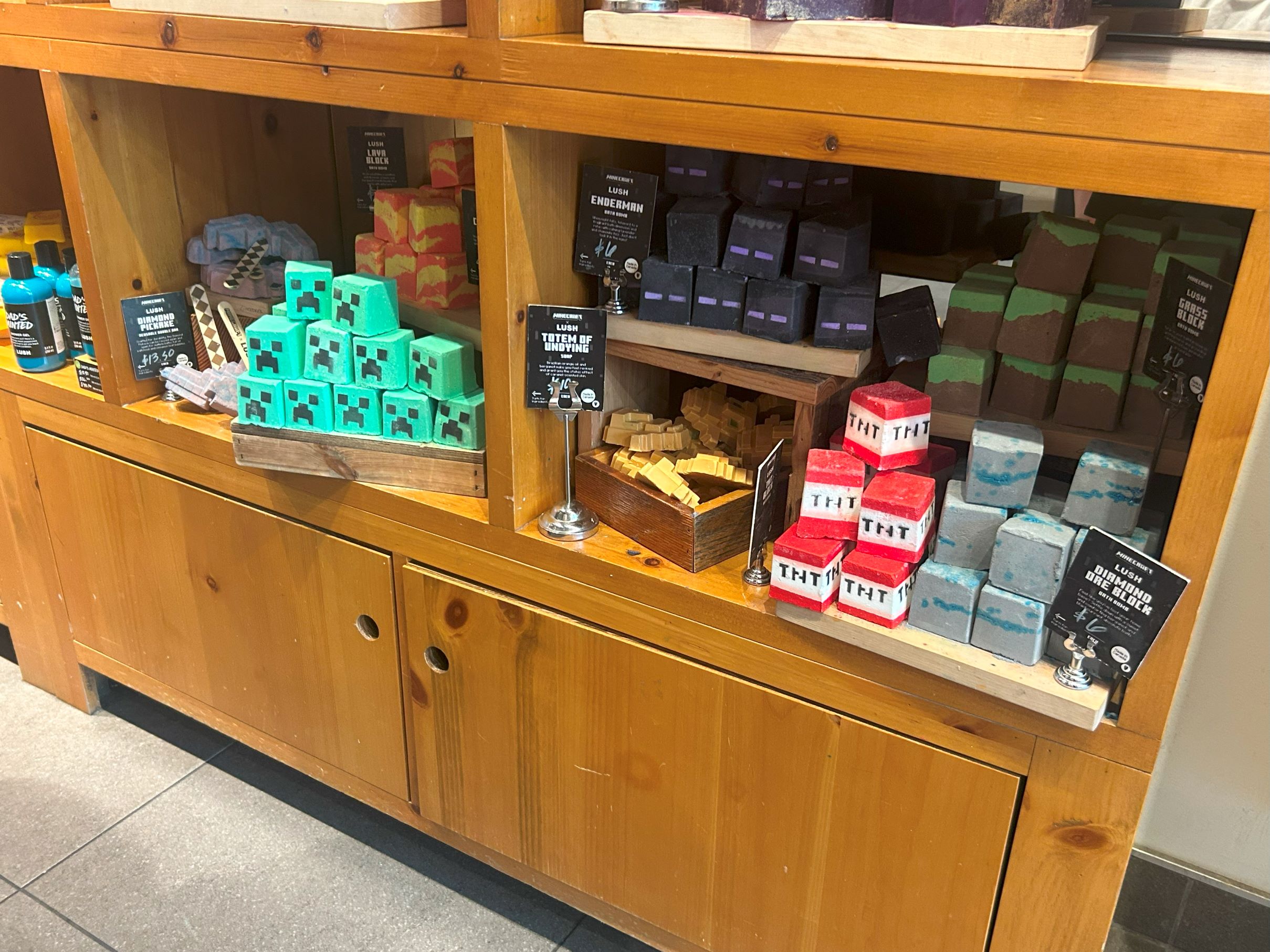 Image of several different Minecraft themed bath bombs, such as TNT blocks, pickaxes, and totems of undying.